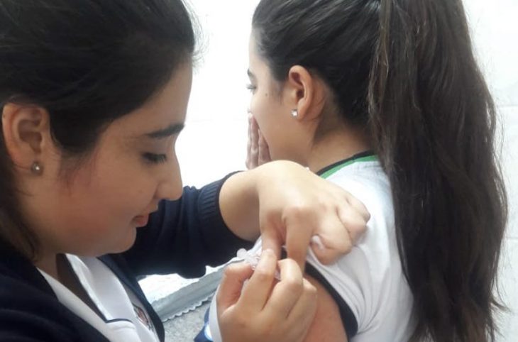 Enfermera vacuna a una joven contra el sarampión