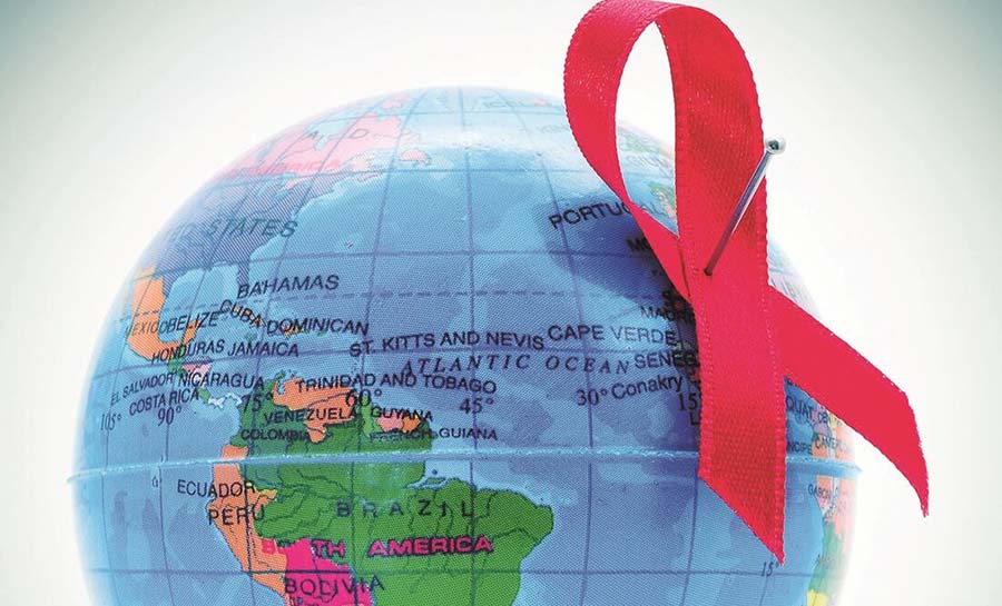 Globo terráqueo con símbolo del VIH-Sida pinchado con un alfiler