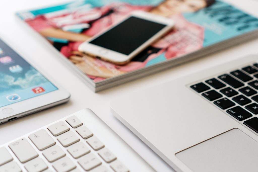 Teléfono y tableta sobre revistas abiertas